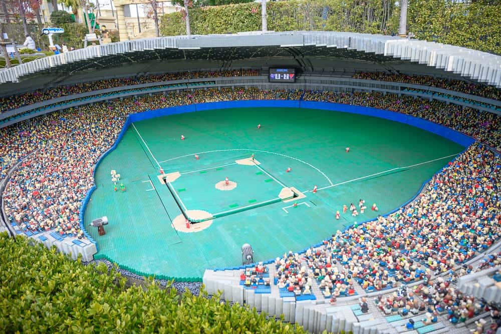 名古屋樂高樂園｜體育場、綠色草坪、藍色邊界、白色線條、觀眾席、觀眾、樹木。