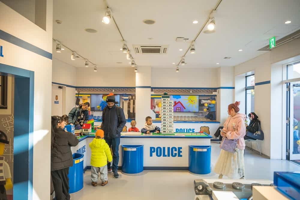 名古屋樂高樂園｜室內，警察局，兒童遊樂場所，樂高玩具，櫃檯，藍色垃圾桶，家長，兒童。