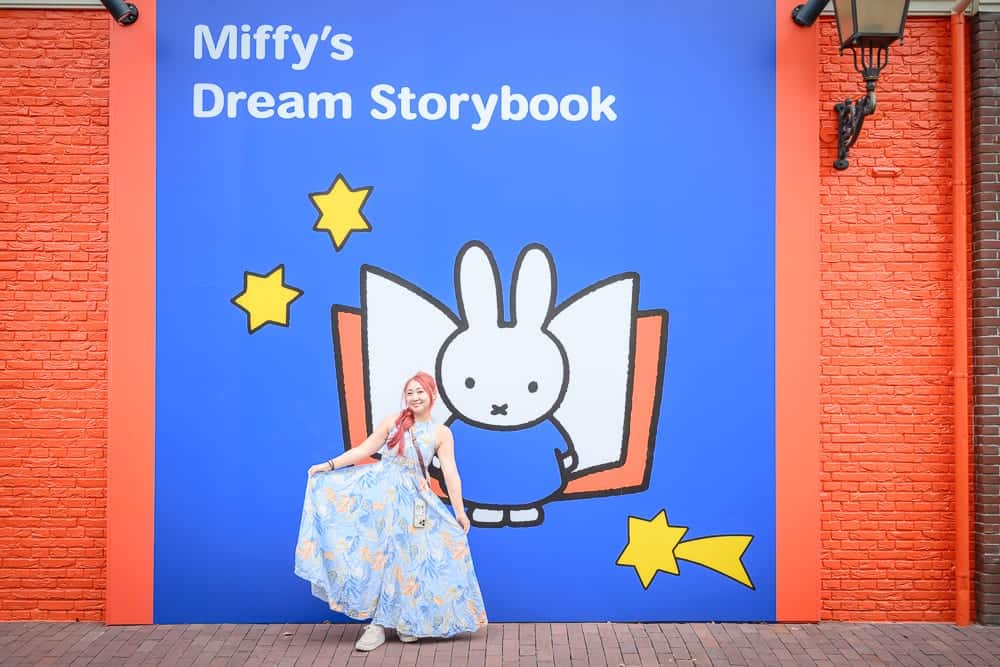 日本長崎-豪斯登堡米菲兔樂園｜女人、長裙、兔子、書、星星、紅色磚牆、藍色牆壁、燈籠、瓷磚地板。