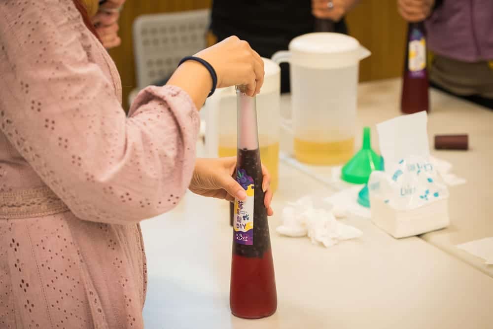 新竹雪霸休閒農場｜室內，桌子，瓶子，容器，紙巾，漏斗，布料，衣服，飲料，食品，人。
