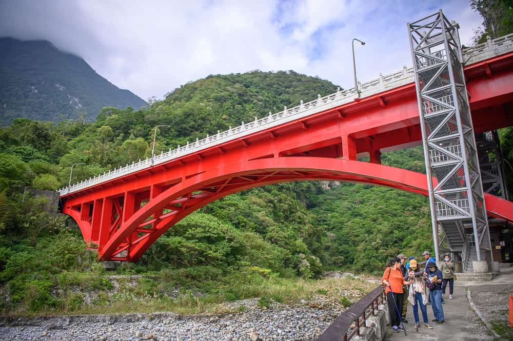 砂卡礑大橋橘紅色拱橋全景與遊客