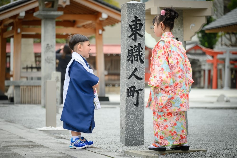日本福岡-警固神社｜兩個小孩，石柱，寺廟，木造建築，日式圍欄，石頭路，寺廟建築，日式建築。