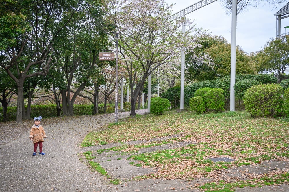 日本名古屋-戶田川綠地公園｜小女孩、道路、草地、樹、秋葉、綠籬、指示牌、建築物、戶外。