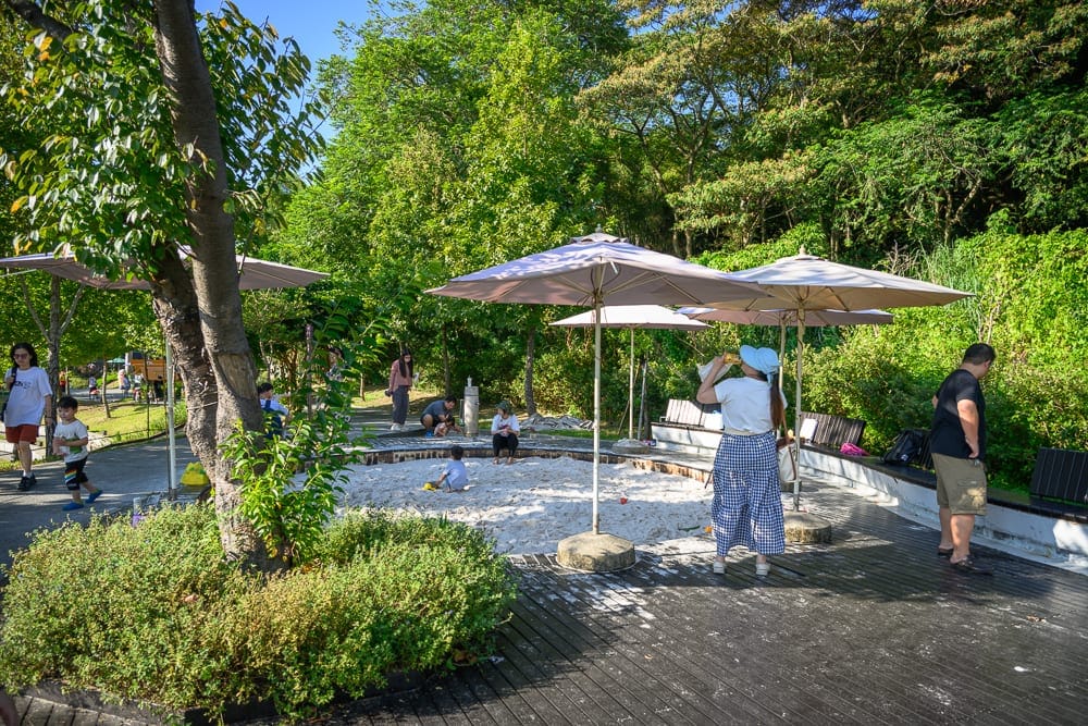 桃園大有梯田生態公園｜園區、樹、草叢、步道、遊客、遮陽傘、沙池、兒童遊樂區、座椅。