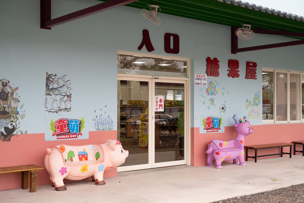 童萌農場入口糖果屋玻璃門，左粉紅豬右紫色鹿造型座椅，營業時間 09:00-17:00