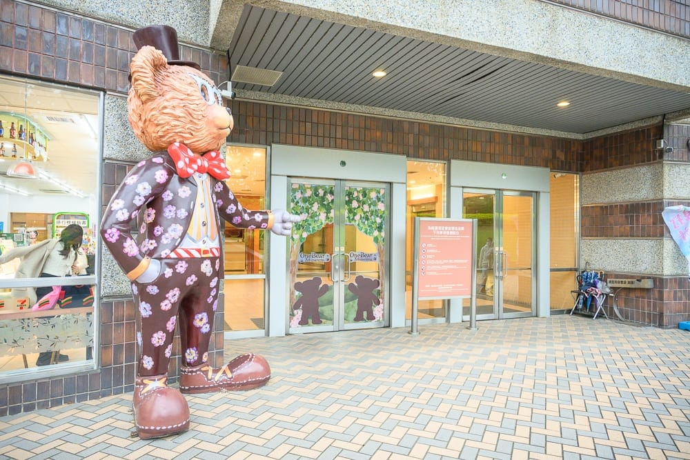 桃園小熊博物館｜大型卡通熊、建築物外牆、入口大門、玻璃窗、瓷磚地板。