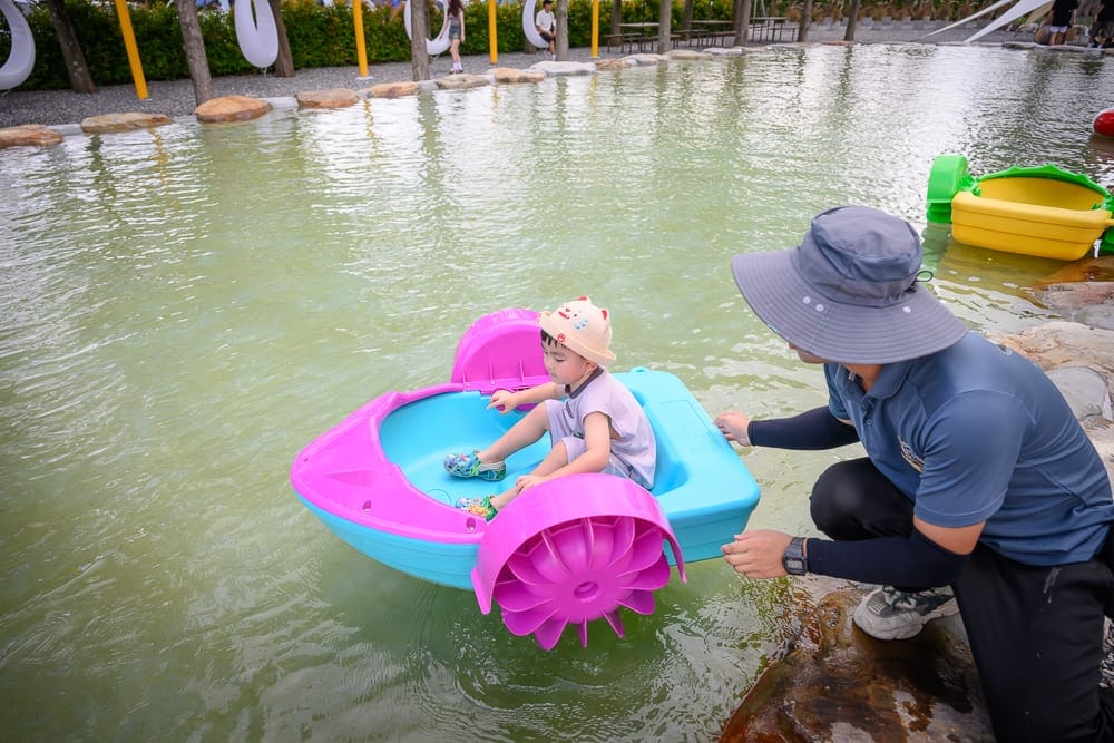 宜蘭樹懶餐廳｜綠色湖水、石頭、兒童、成人、腳踏船、黃色腳踏船。綠色湖水、石頭、兒童、成人、腳踏船、黃色腳踏船。 一