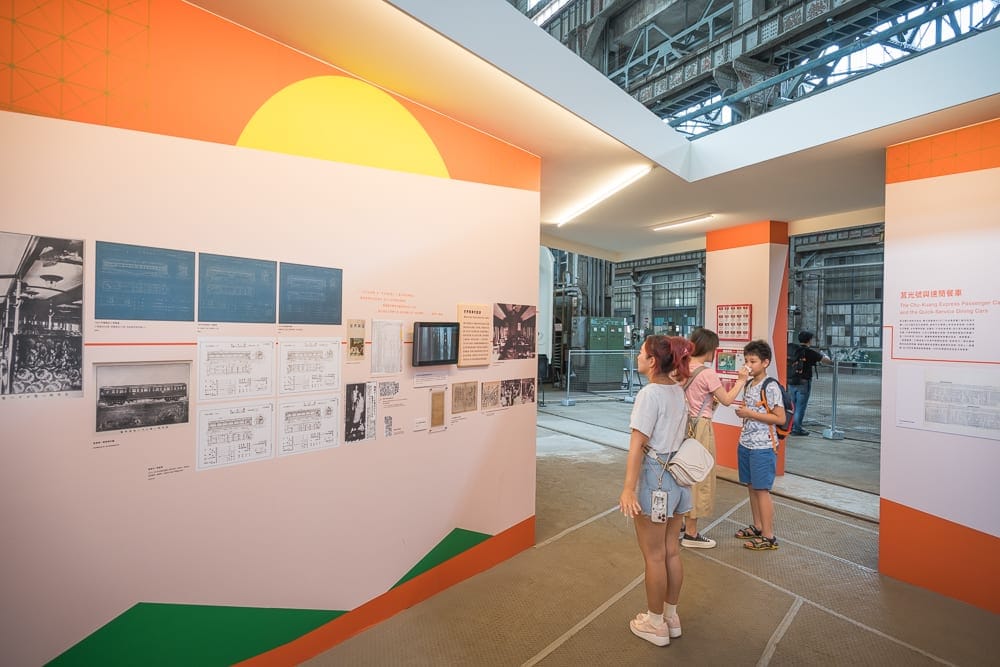 台北國家鐵道博物館｜室內，展覽空間，牆壁，白牆，橙色裝飾，圖片，文字，展板，訪客，兒童，成人。