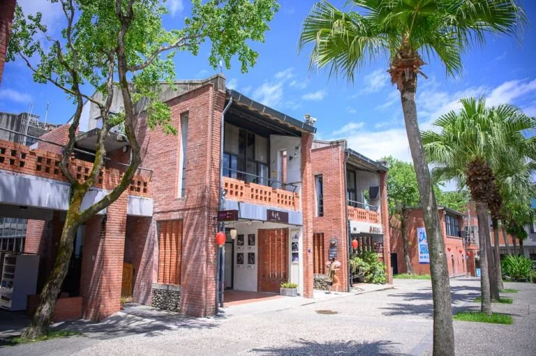 宜蘭傳藝文化園區｜紅磚建築群，街道，椰子樹，樹木，藍天，窗戶，招牌，紅色燈籠，戶外廣場。