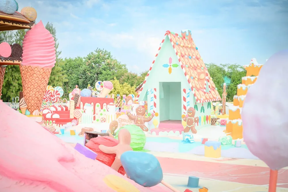 泰國芭達雅GREAT&GRAND Sweet Destination｜戶外糖果樂園，大型冰淇淋模型，薑餅屋，糖果裝飾，粉嫩色系，藍天綠樹背景，色彩繽紛