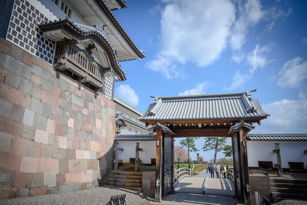 日本金澤-金澤城公園｜石牆、城堡、城門、瓦片屋頂、藍天、白雲、木造建築、遊客。