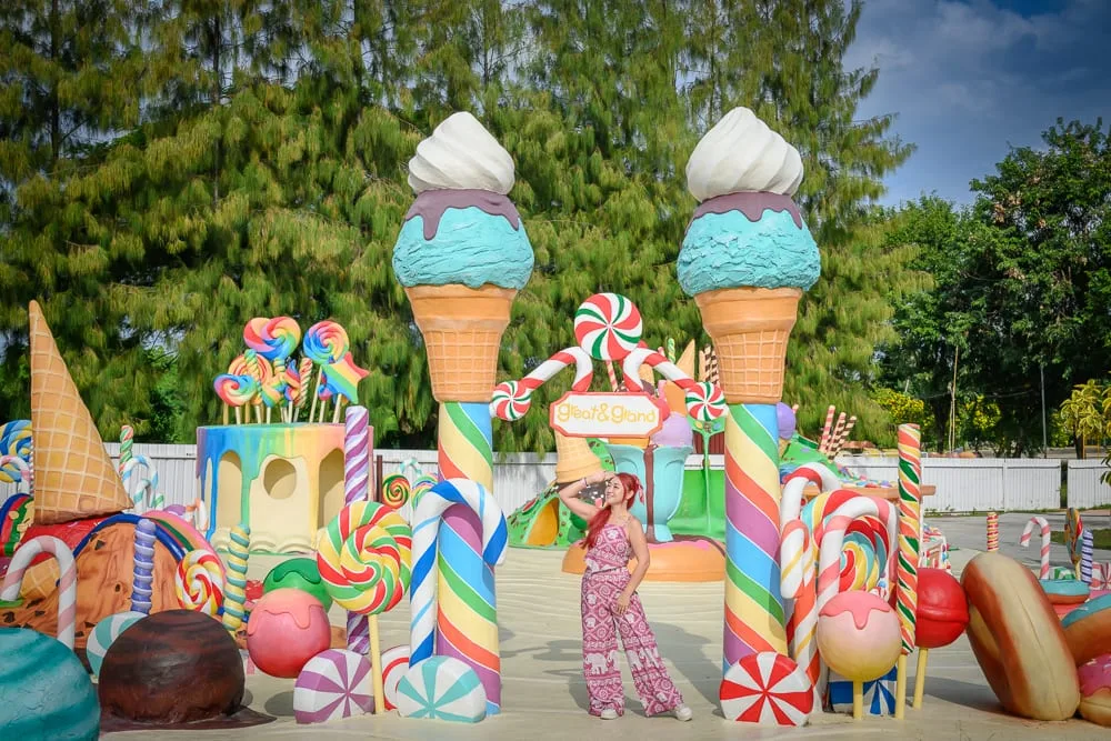 泰國芭達雅GREAT&GRAND Sweet Destination｜巨型冰淇淋模型、糖果、甜甜棒、女子、戶外廣場、樹木。