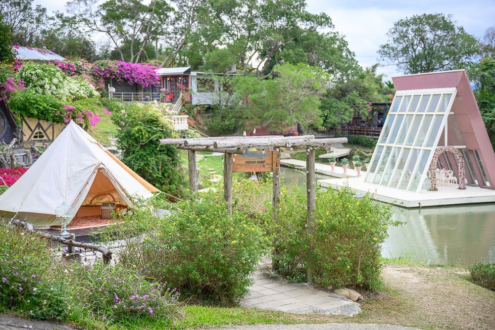 苗栗格林奇幻森林 Green Fantasy Forest 完整指南|童話建築與玻璃屋園區玩法解析 8 苗栗格林奇幻森林|帳篷、木橋、玻璃屋、池塘、草叢、石徑、樹,花叢,建築物。