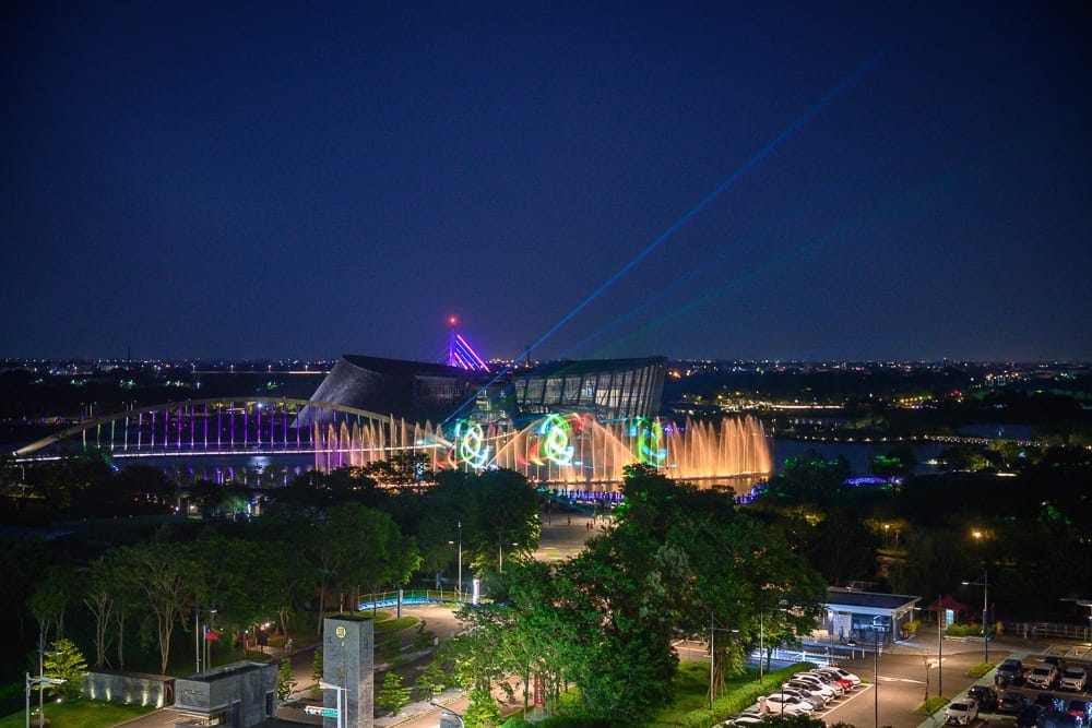 嘉義長榮文苑酒店｜夜空下的現代建築物，建築物、橋、水舞、雷射光、夜景，呈現色彩繽紛、熱鬧繁華的氛圍。