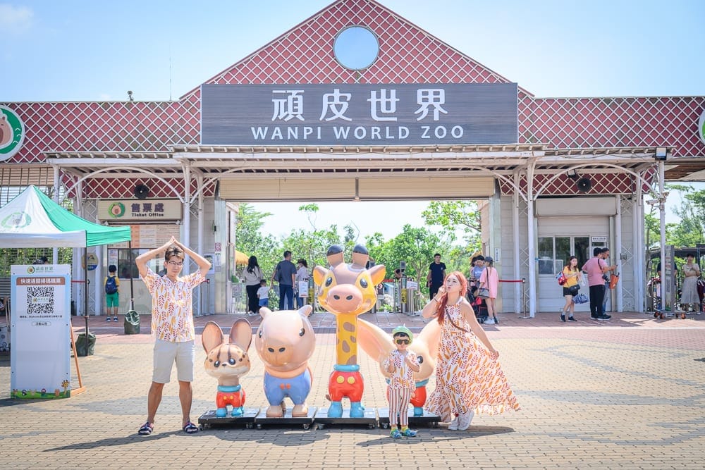 台南頑皮世界｜動物園大門入口、招牌、長頸鹿公仔、水豚公仔、狐獴公仔、磚造建築、廣場、遊客