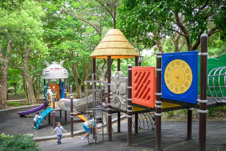 桃園奧爾森林學堂｜公園，兒童遊樂場，塑膠遊具，溜滑梯，攀爬架，樹林，幾位孩童，陰天光線