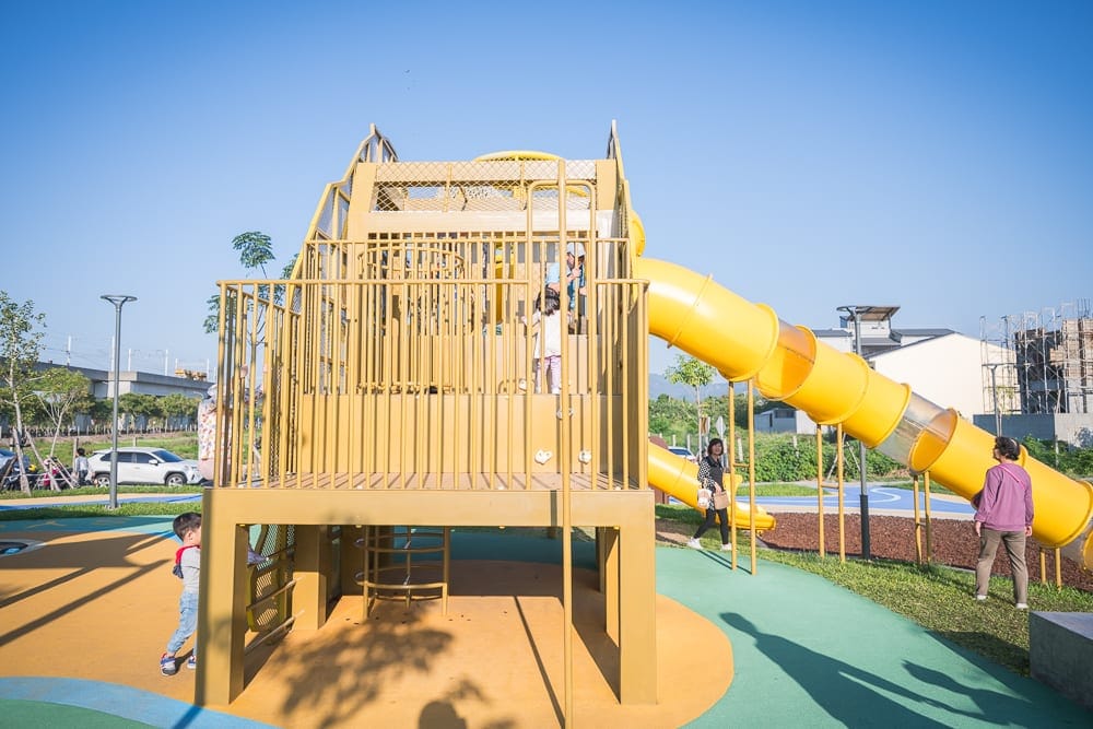 彰化熊趣米公園｜戶外公園，大型黃色攀爬架，旋轉滑梯，孩童，大人，綠地，藍天，路燈