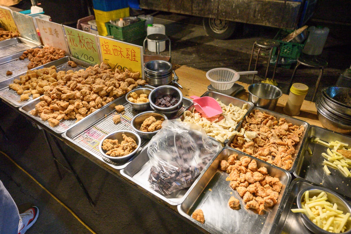 彰化田尾公路花園夜市｜夜市攤位，料理，炸物，金黃薯條，招牌，鐵盤，金屬碗，塑膠袋裝食材，夜市，金黃色調，油炸食物，金屬夾具