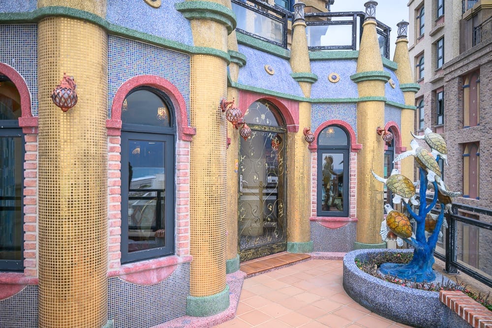 花蓮七星潭水上明月海景渡假旅店 Hotelmoon 完整攻略|歐式城堡建築與住宿體驗 7 花蓮水上明月海景旅店|城堡、圓柱、馬賽克磁磚、拱形窗戶、雕花玻璃門、戶外露台、海龜雕塑,色彩繽紛的建築外牆拼貼金色與藍色小
