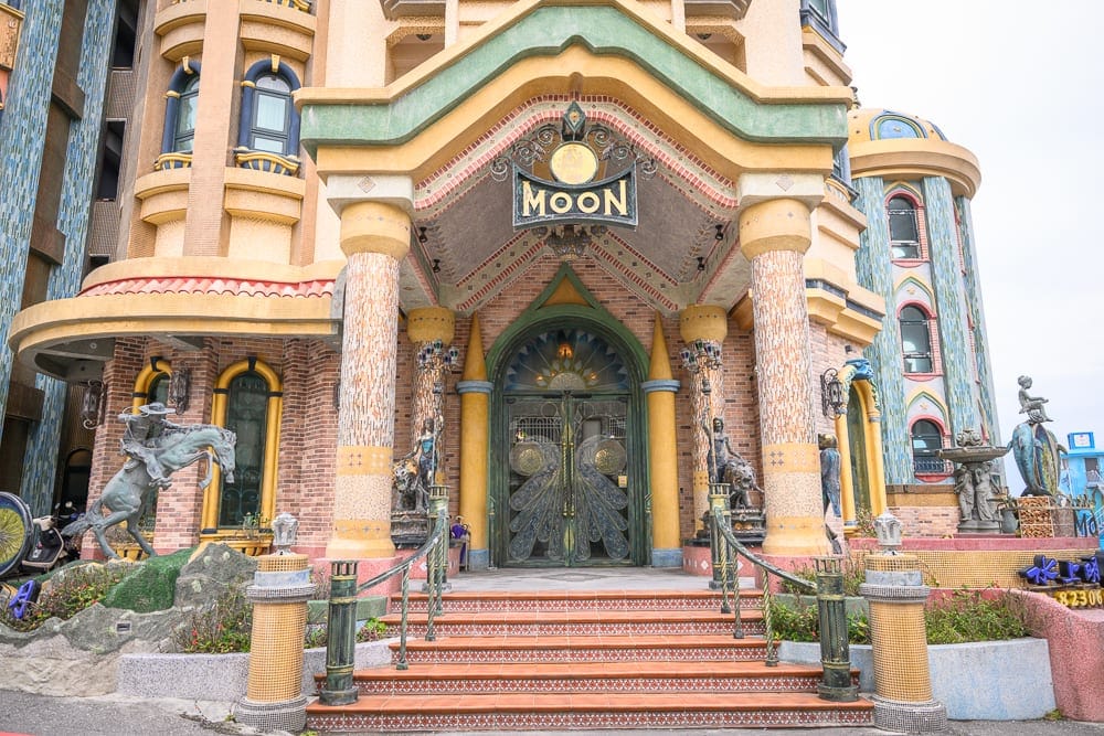 花蓮七星潭水上明月海景渡假旅店 Hotelmoon 完整攻略|歐式城堡建築與住宿體驗 10 花蓮水上明月海景旅店|歐式建築風格入口,階梯,雙柱,雕花大門,招牌MOON,騎馬銅像,噴泉雕塑,圓拱窗戶,馬賽克拼貼牆面。