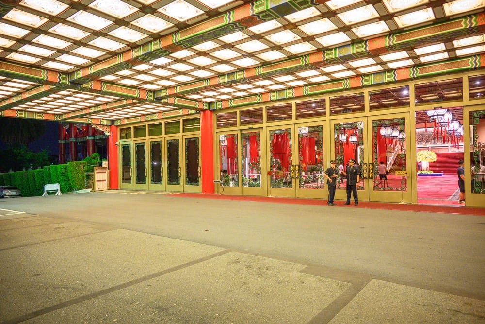 台北圓山大飯店完整攻略|宮殿建築外觀與密道體驗解析 6 台北圓山大飯店|室內、廣場、大門、屋頂、穿廊、燈籠、柱子。挑高的大廳外廊道,鋪著方格照明的天花板與紅綠相間的傳統樑柱