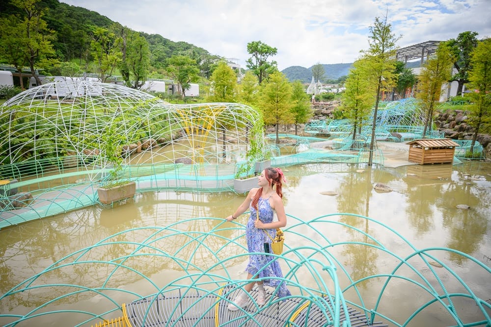 新北亮山川景觀休閒園區｜女子，水池，金屬鐵網裝置藝術，落羽松，山景，戶外園區，多雲天光。