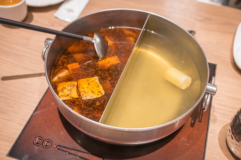 高雄福華大飯店完整攻略|屋頂泳池、早餐自助與尊爵房型解析 11 高雄福華飯店|料理,鴛鴦鍋,金屬鍋具,麻辣湯底,清湯,湯勺,木紋桌面,電磁爐