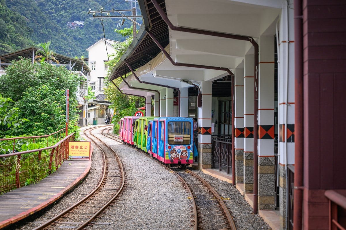 烏來台車攻略|票價、營運時間、搭乘動線與瀑布站一次看 2 新北烏來站軌道與停靠的彩色觀光台車