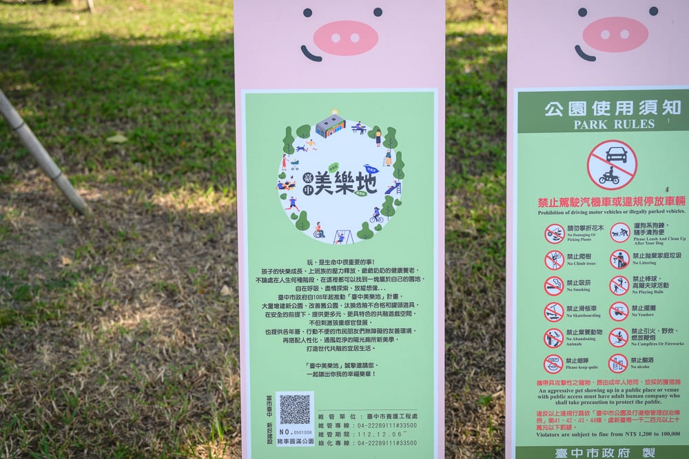 台中豬事圓滿公園｜粉紅色豬臉圖案的木製告示牌，草地，公園使用須知，文字說明，插圖，戶外。