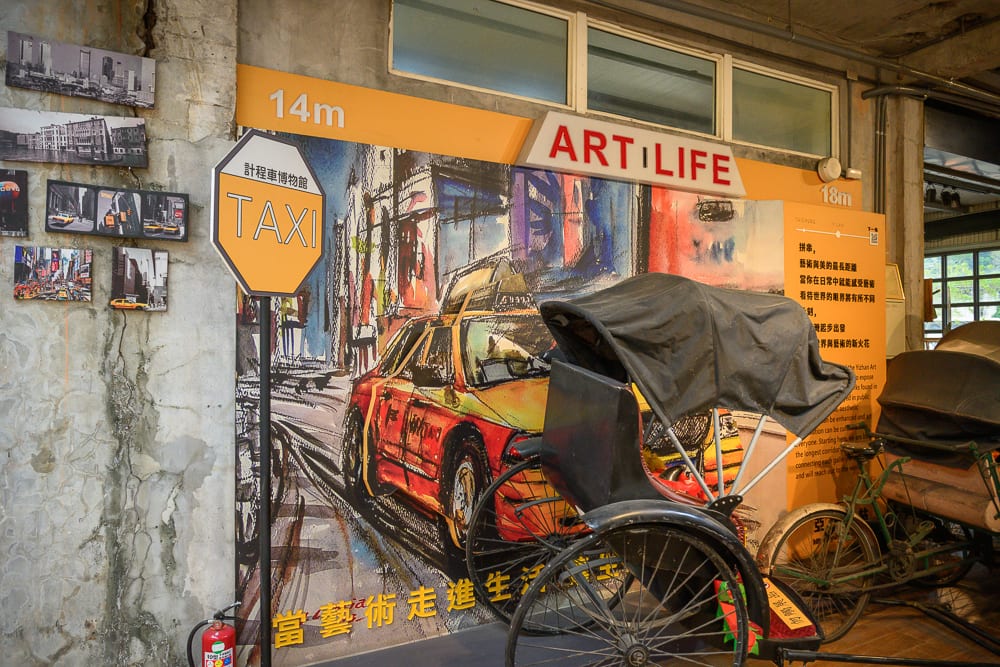 宜蘭計程車博物館｜室內，計程車招牌，人力車，壁畫，斑駁水泥牆，金屬窗框，黃色橘色背板，攝影作品掛牆，展示空間。