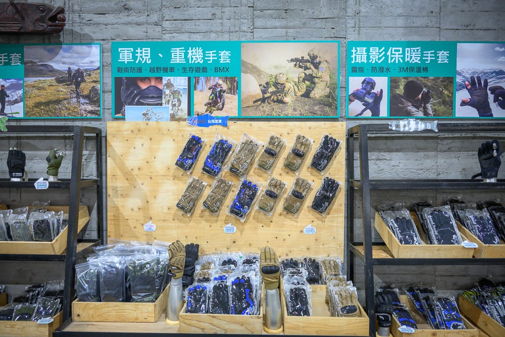 彰化台灣手套博物館｜室內，商店，手套，展示架，木板牆，看板。水泥牆面下方架設木質展台與黑色金屬貨架，牆面懸掛三幅綠底宣傳