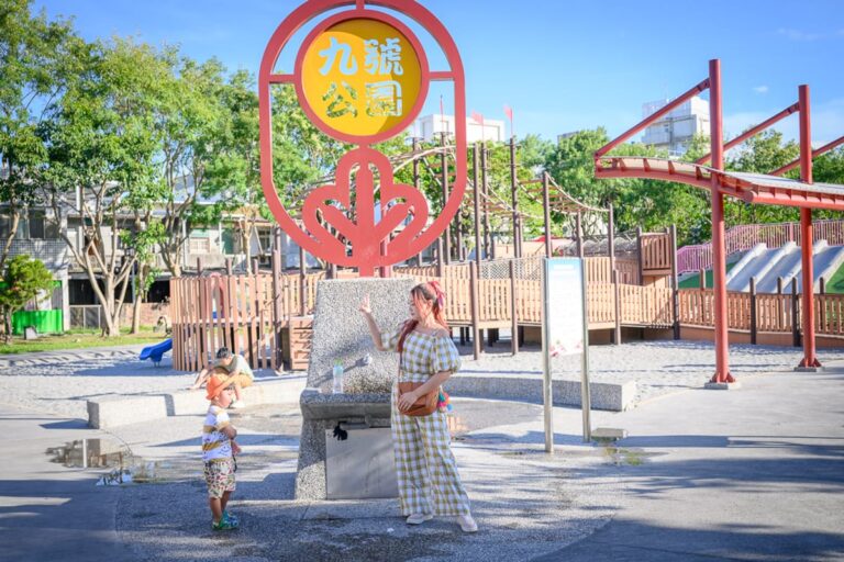 宜蘭九號公園｜公園，立牌，飲水機，婦人，小孩，木製遊樂設施，溜滑梯，建築物，樹木。戶外廣場立著「九號公園」圓形紅框