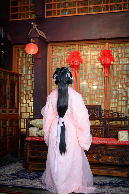 台中RJ55漢服完整指南|漢服服飾與古風配件 5 台中RJ55漢服|室內,粉紅古裝女子,背影,黑色長髮,木製家具,紅燈籠,窗格,地毯