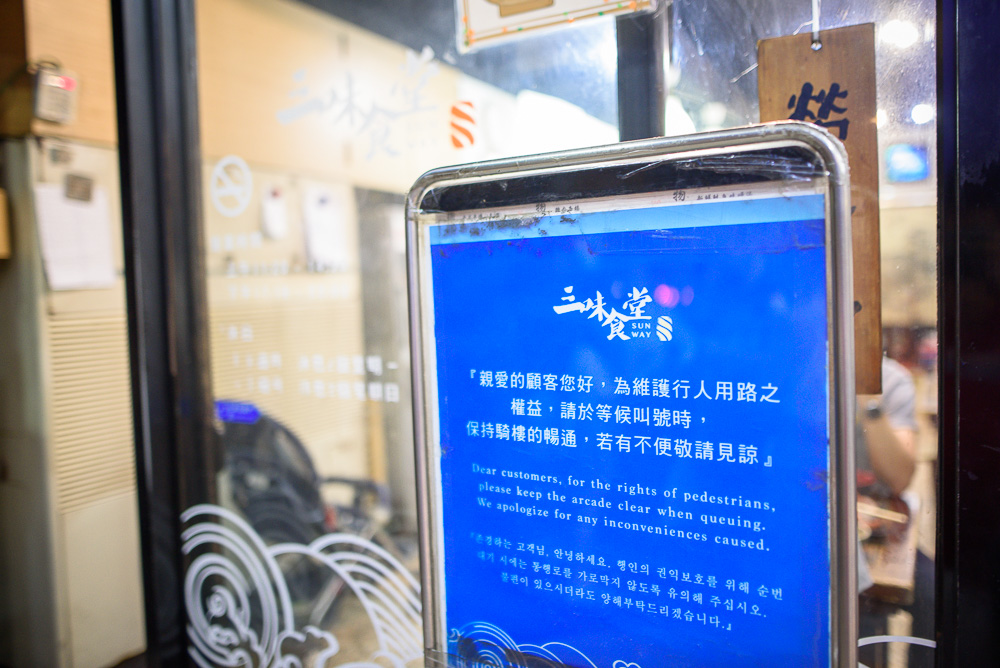 台北三味食堂｜餐廳門口，張貼著請排隊顧客保持騎樓暢通的藍色告示牌。