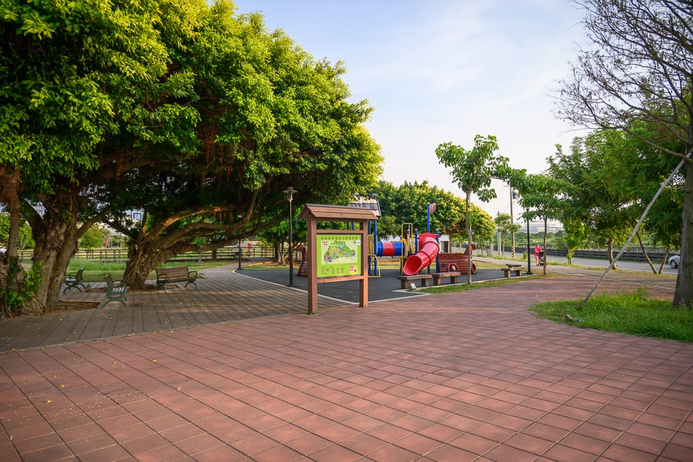 桃園海寧公園兒童遊戲場完整指南|螺旋滑梯與遊具玩法 6 桃園海寧公園|紅磚廣場,大樹,長椅,告示牌,兒童遊樂場,溜滑梯,綠地,人行道,戶外空間