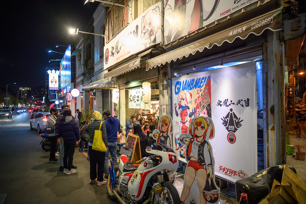 台中火曜二代目拉麵｜夜間街頭，動漫風格拉麵店，排隊人潮，造型立牌，改裝機車。