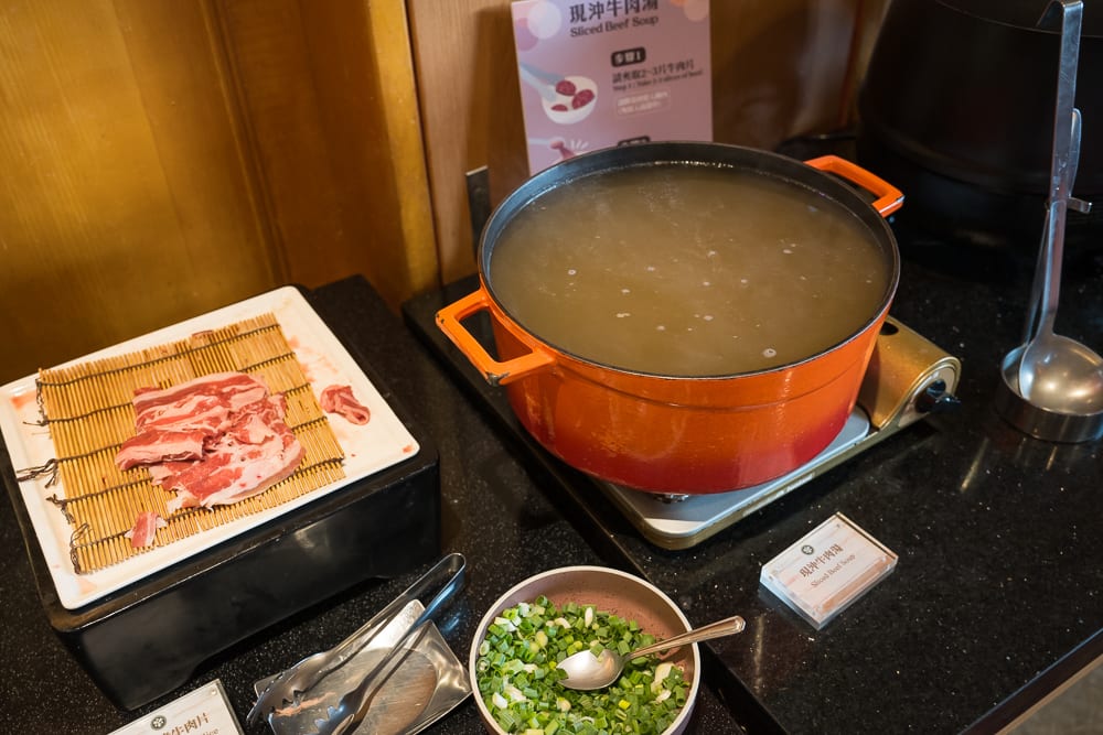 桃園悅華大飯店｜室內自助吧台，橘色湯鍋、生牛肉片、蔥花碗、湯勺、說明立牌。