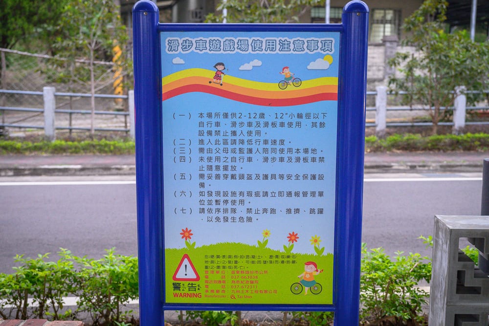 苗栗滑步車公園｜藍色金屬告示牌，告示牌，文字，兒童插圖，馬路，綠色植栽。